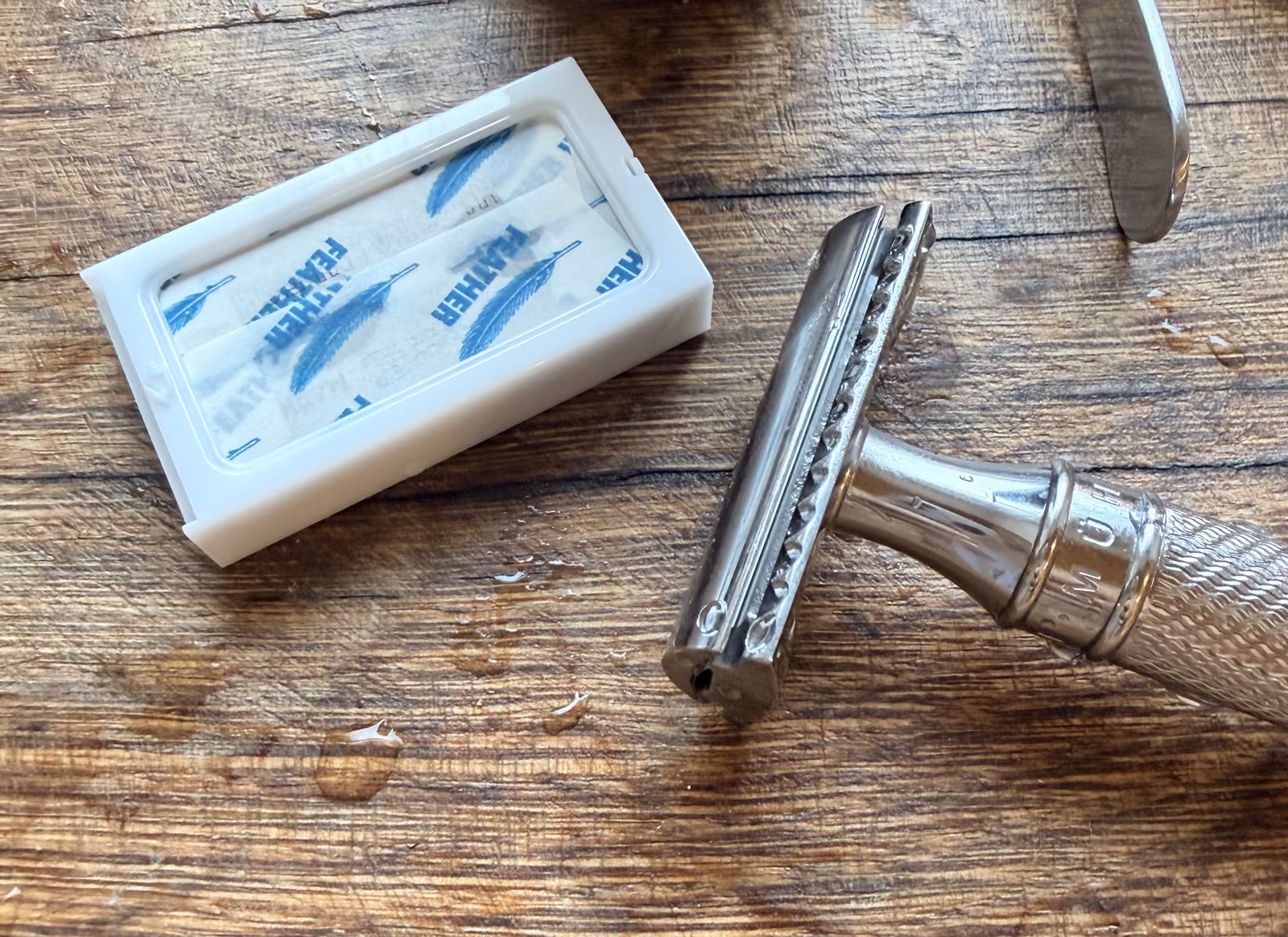 My metal MÜHLE safety razor beside an open dispenser of wrapped Feather blades